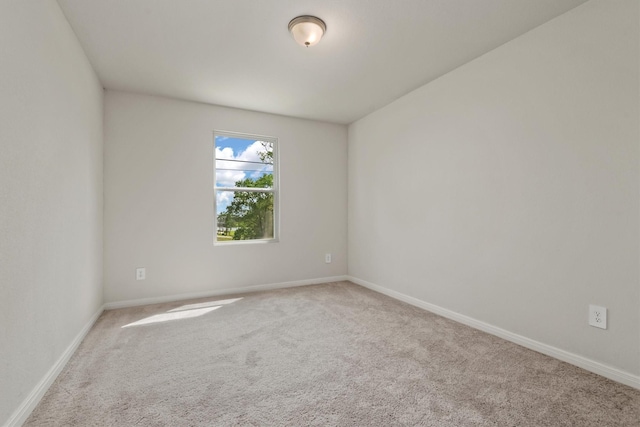 empty room featuring baseboards and carpet flooring