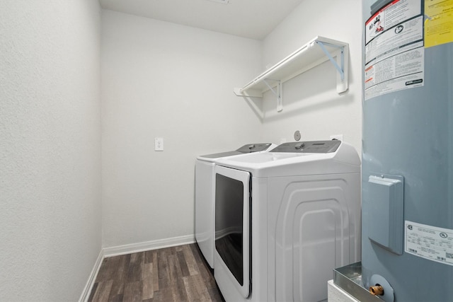 laundry room with dark wood-style flooring, washing machine and dryer, baseboards, water heater, and laundry area