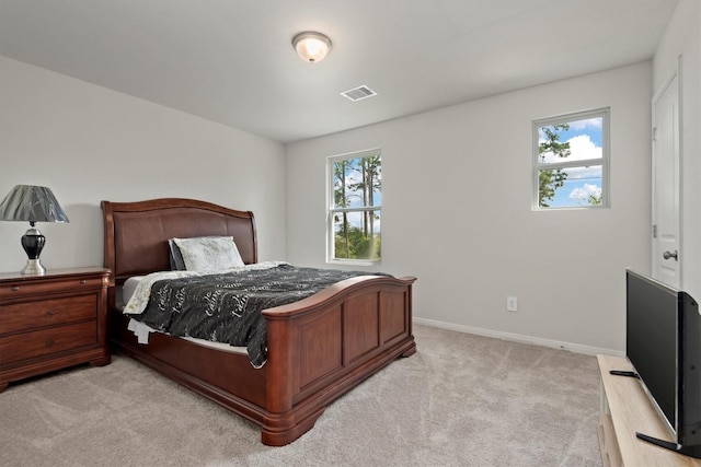bedroom featuring baseboards, visible vents, and light colored carpet