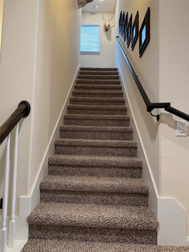 staircase featuring a textured wall