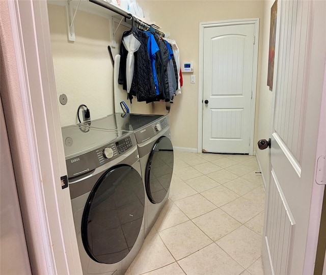 washroom featuring separate washer and dryer, baseboards, laundry area, and light tile patterned flooring