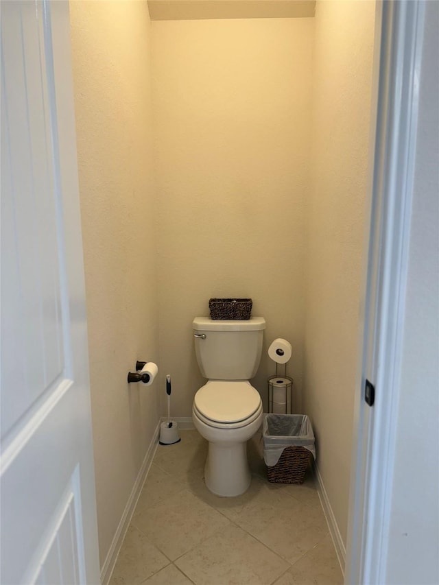 bathroom featuring toilet, tile patterned flooring, and baseboards