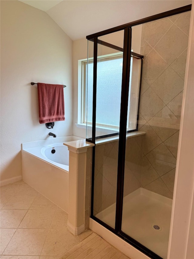 bathroom featuring a shower stall, lofted ceiling, tile patterned floors, a bath, and baseboards