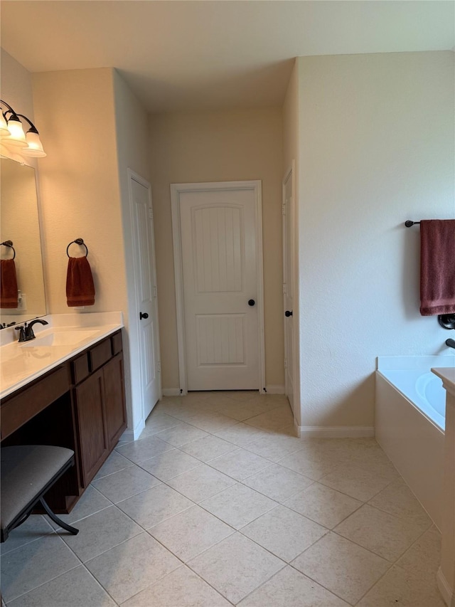 full bathroom with baseboards, a garden tub, vanity, and tile patterned flooring