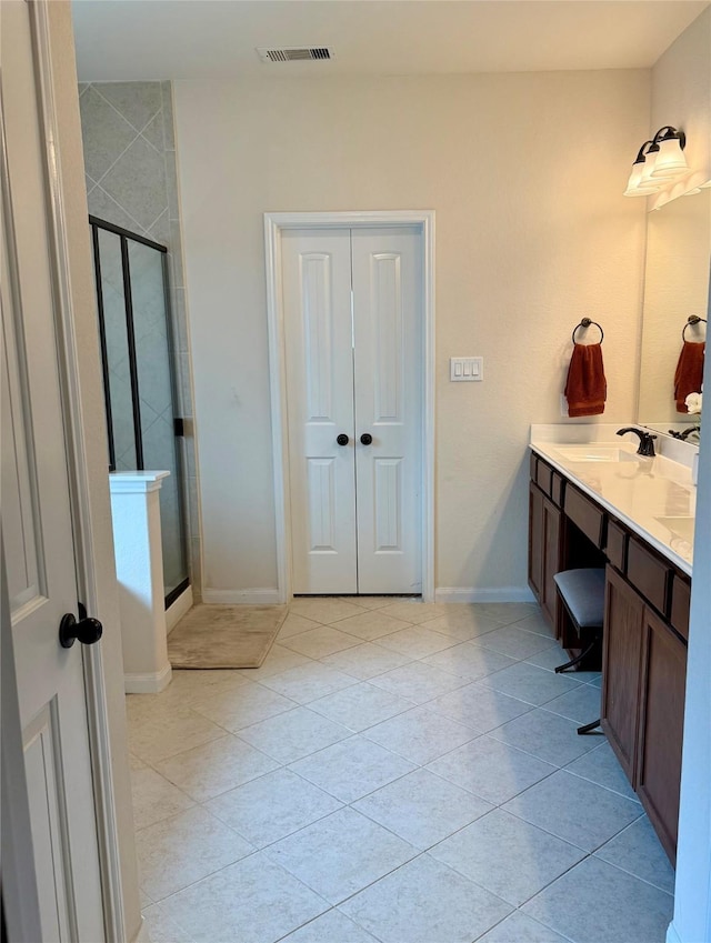 bathroom featuring a shower stall, tile patterned floors, double vanity, and visible vents