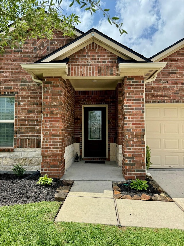 doorway to property with brick siding and a garage