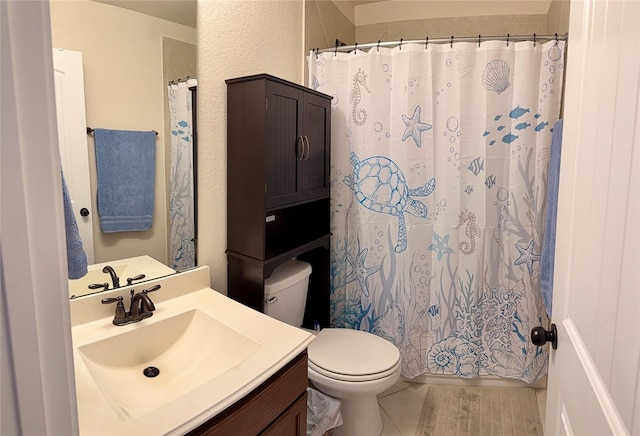 bathroom featuring wood finished floors, toilet, vanity, and a shower with curtain