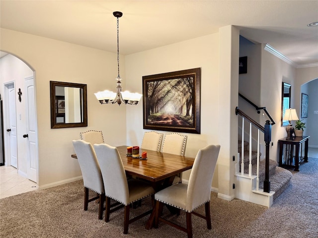 dining area featuring carpet, stairway, arched walkways, crown molding, and a chandelier