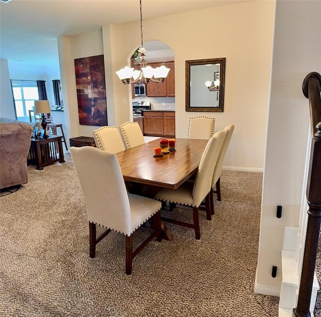 dining room with light colored carpet, arched walkways, baseboards, and a notable chandelier