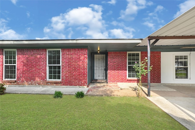 exterior space with brick siding and a lawn