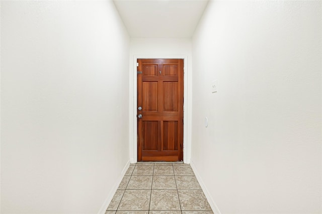 entryway with baseboards and light tile patterned floors