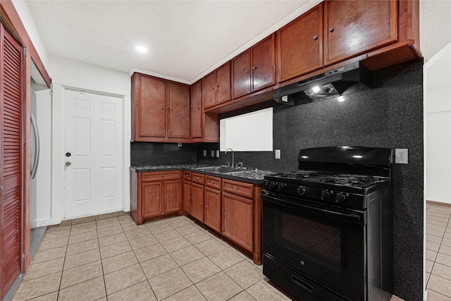 kitchen featuring a sink, backsplash, black gas range oven, under cabinet range hood, and light tile patterned floors