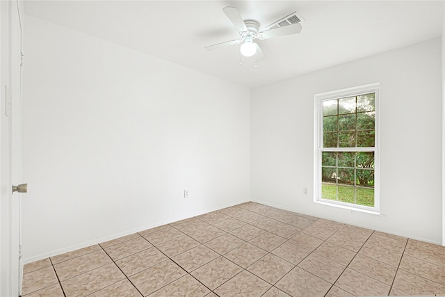 empty room featuring a ceiling fan, light tile patterned flooring, and visible vents
