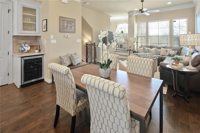 dining area featuring dark wood-type flooring, a wealth of natural light, a ceiling fan, and wine cooler