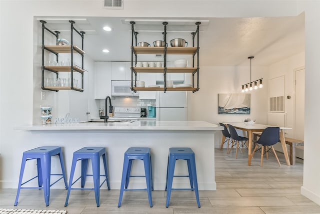 kitchen with open shelves, white appliances, a sink, and white cabinets