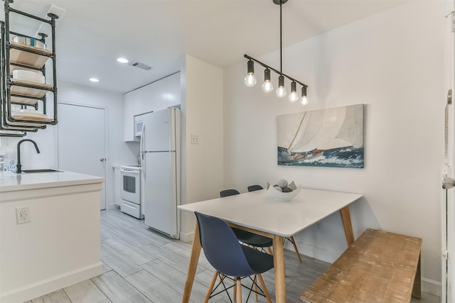 dining room with recessed lighting, light wood-style flooring, visible vents, and baseboards