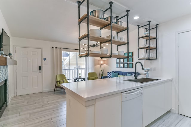 kitchen featuring a peninsula, a sink, a wealth of natural light, open shelves, and dishwasher