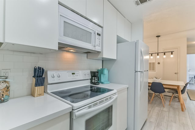 kitchen featuring white cabinets, light countertops, tasteful backsplash, and white appliances