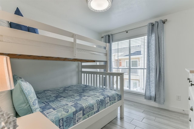 bedroom with wood tiled floor and multiple windows