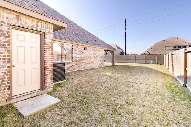 view of yard with a fenced backyard and central air condition unit