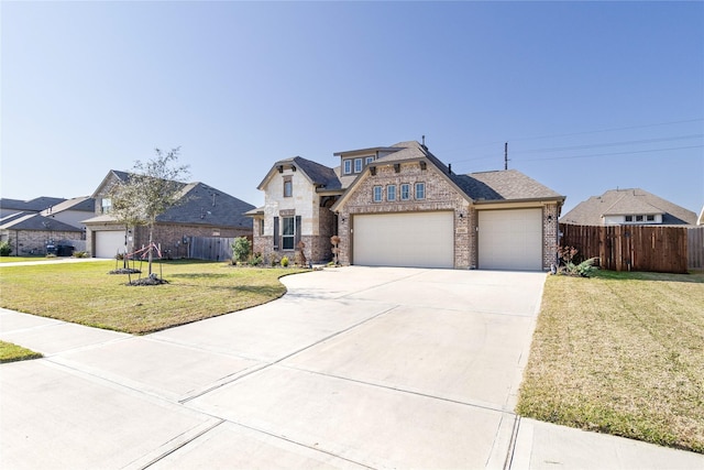 french country inspired facade with a garage, a front lawn, concrete driveway, and fence