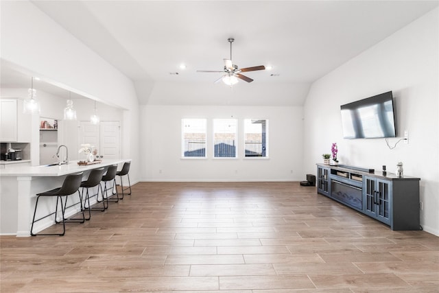 living room with recessed lighting, light wood finished floors, vaulted ceiling, and a ceiling fan