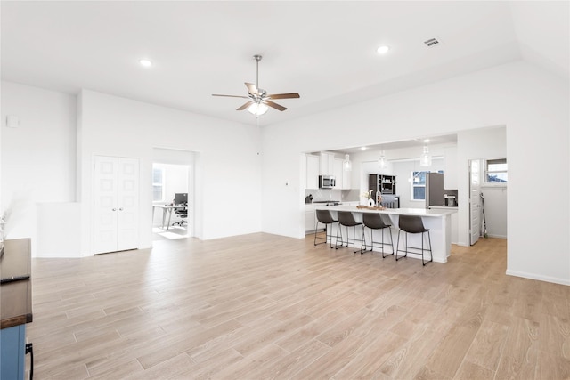 living room featuring recessed lighting, light wood-style floors, visible vents, and a ceiling fan