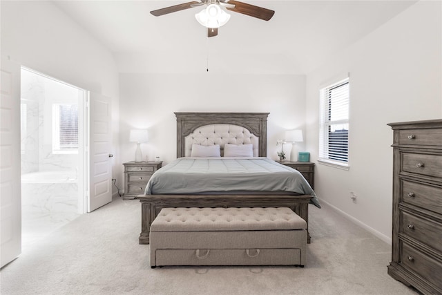 bedroom with lofted ceiling, ensuite bath, light colored carpet, and ceiling fan