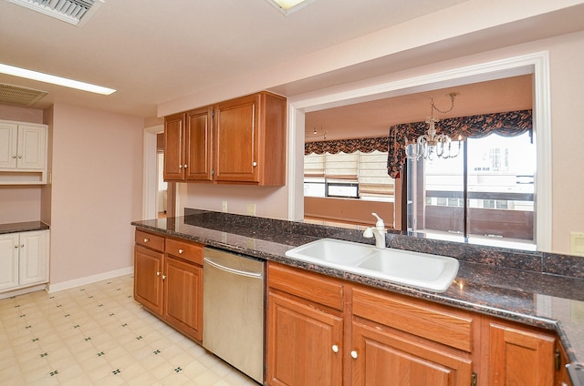 kitchen featuring stainless steel dishwasher, a sink, brown cabinets, light floors, and visible vents