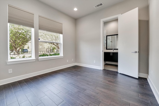 spare room featuring recessed lighting, visible vents, baseboards, and dark wood-style flooring