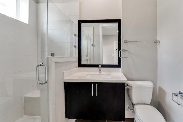 full bath featuring toilet, vanity, and a stall shower