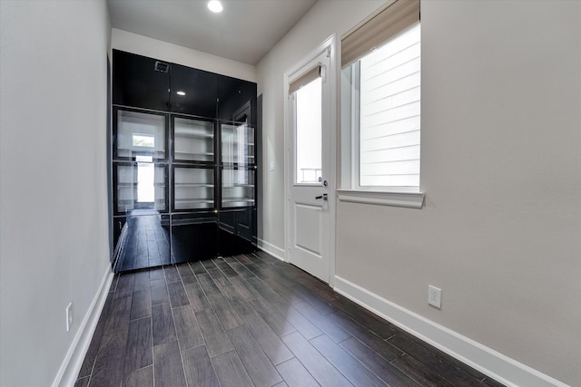 interior space with dark wood-type flooring and baseboards
