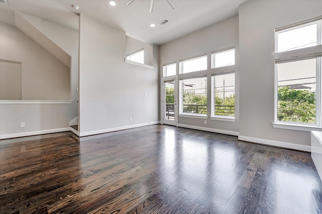 unfurnished room featuring a healthy amount of sunlight, wood finished floors, and visible vents