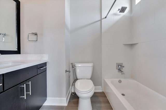 bathroom featuring bathing tub / shower combination, baseboards, vanity, and toilet