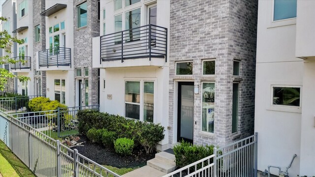 view of exterior entry featuring stucco siding and fence