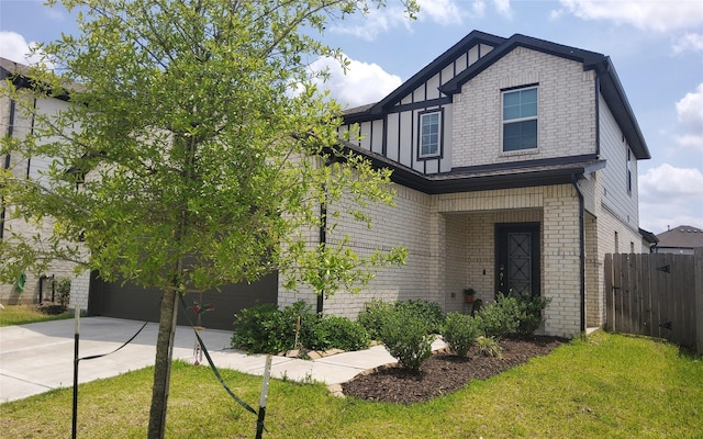 tudor home featuring brick siding, a front lawn, fence, and driveway