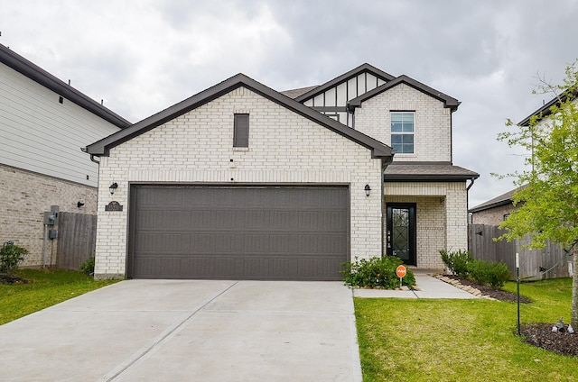 view of front of home with driveway, brick siding, fence, a front lawn, and an attached garage
