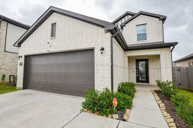 view of front of home featuring brick siding, a garage, fence, and driveway