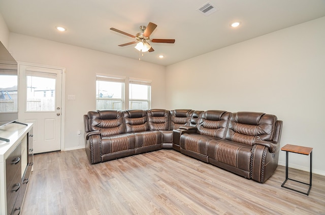 living area featuring visible vents, a ceiling fan, baseboards, and light wood-type flooring