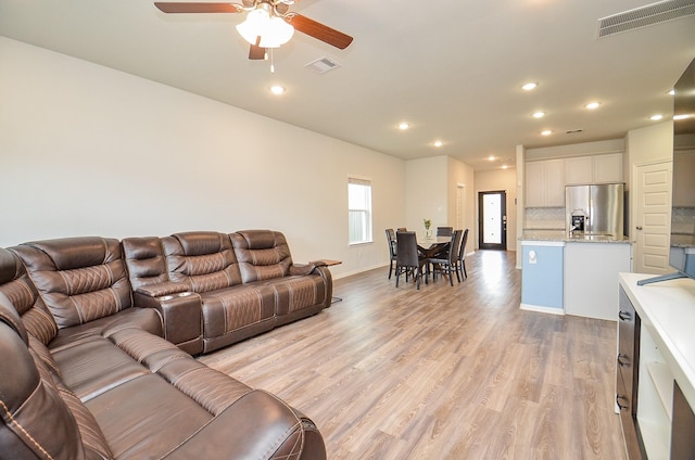 living room featuring recessed lighting, ceiling fan, visible vents, and light wood-style floors