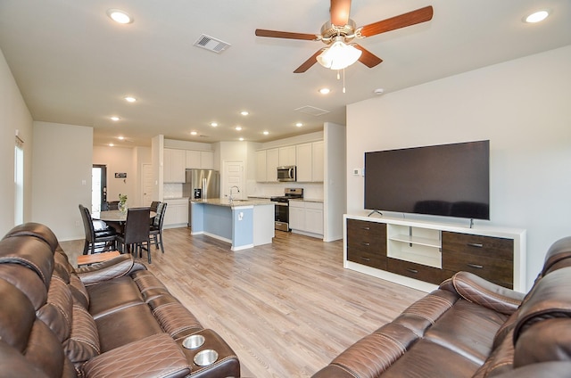 living area featuring light wood-style floors, a ceiling fan, recessed lighting, and visible vents