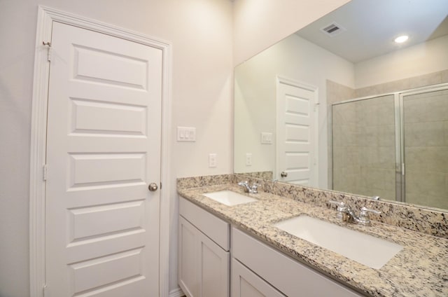 full bath featuring double vanity, visible vents, a sink, and a stall shower