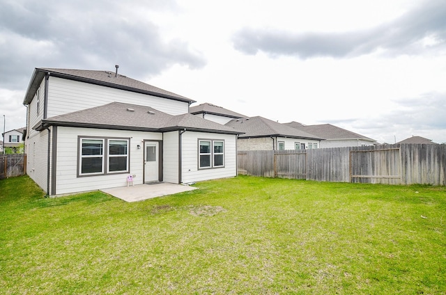 rear view of property with a fenced backyard, a lawn, and a patio area