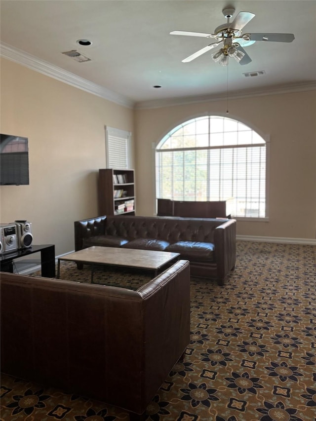 living room featuring baseboards, ornamental molding, a ceiling fan, and visible vents