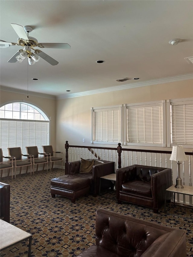 living area with crown molding, a ceiling fan, carpet flooring, and visible vents