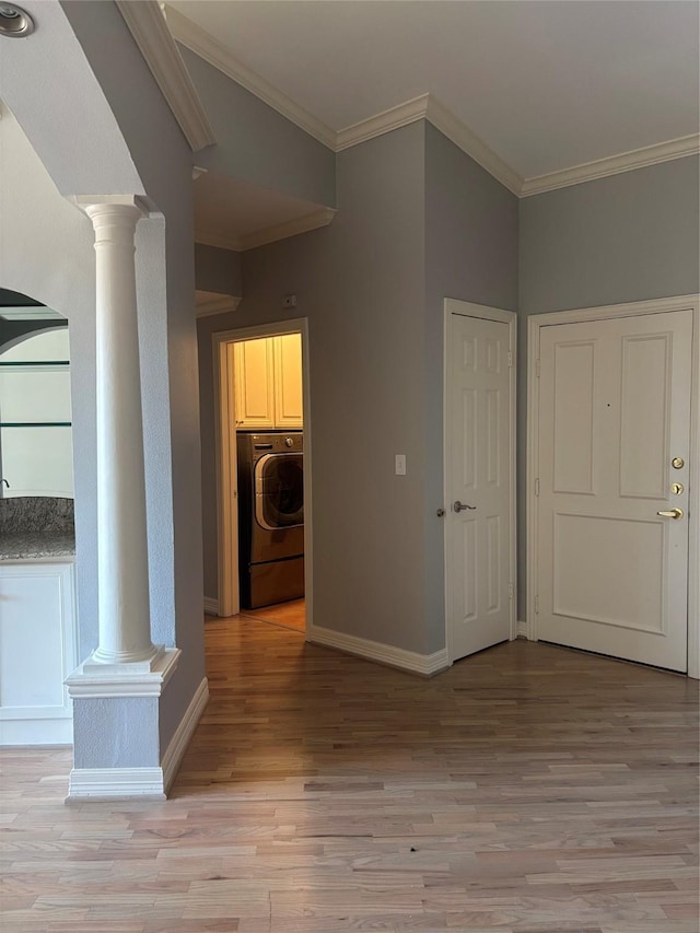 interior space featuring washer / dryer, ornamental molding, light wood finished floors, and ornate columns