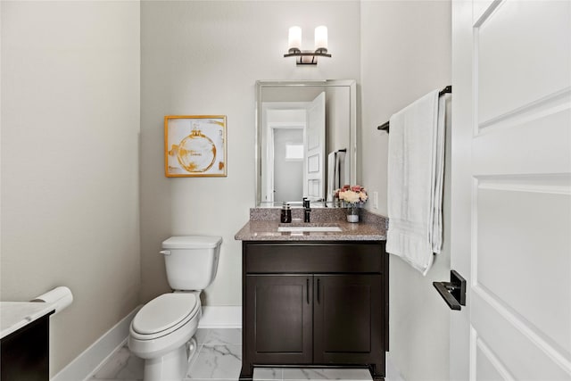half bathroom with baseboards, marble finish floor, vanity, and toilet