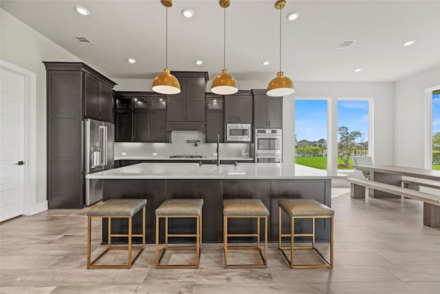 kitchen featuring backsplash, appliances with stainless steel finishes, a sink, and visible vents