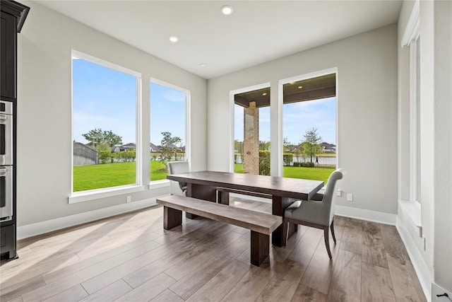 dining area with recessed lighting, light wood-style floors, and baseboards