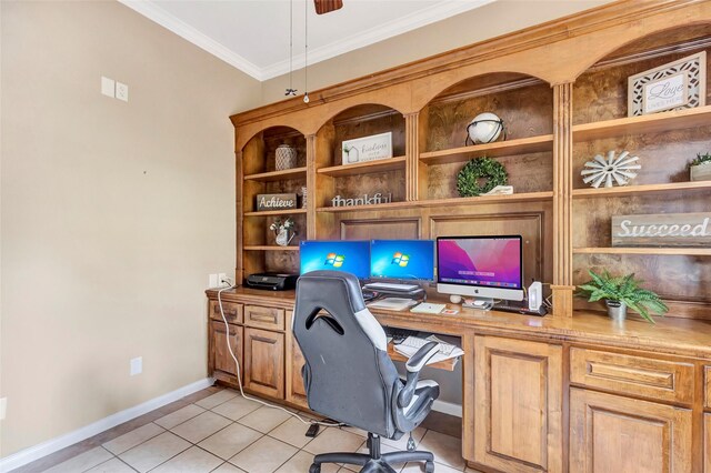 office area with light tile patterned floors, built in desk, ceiling fan, baseboards, and ornamental molding